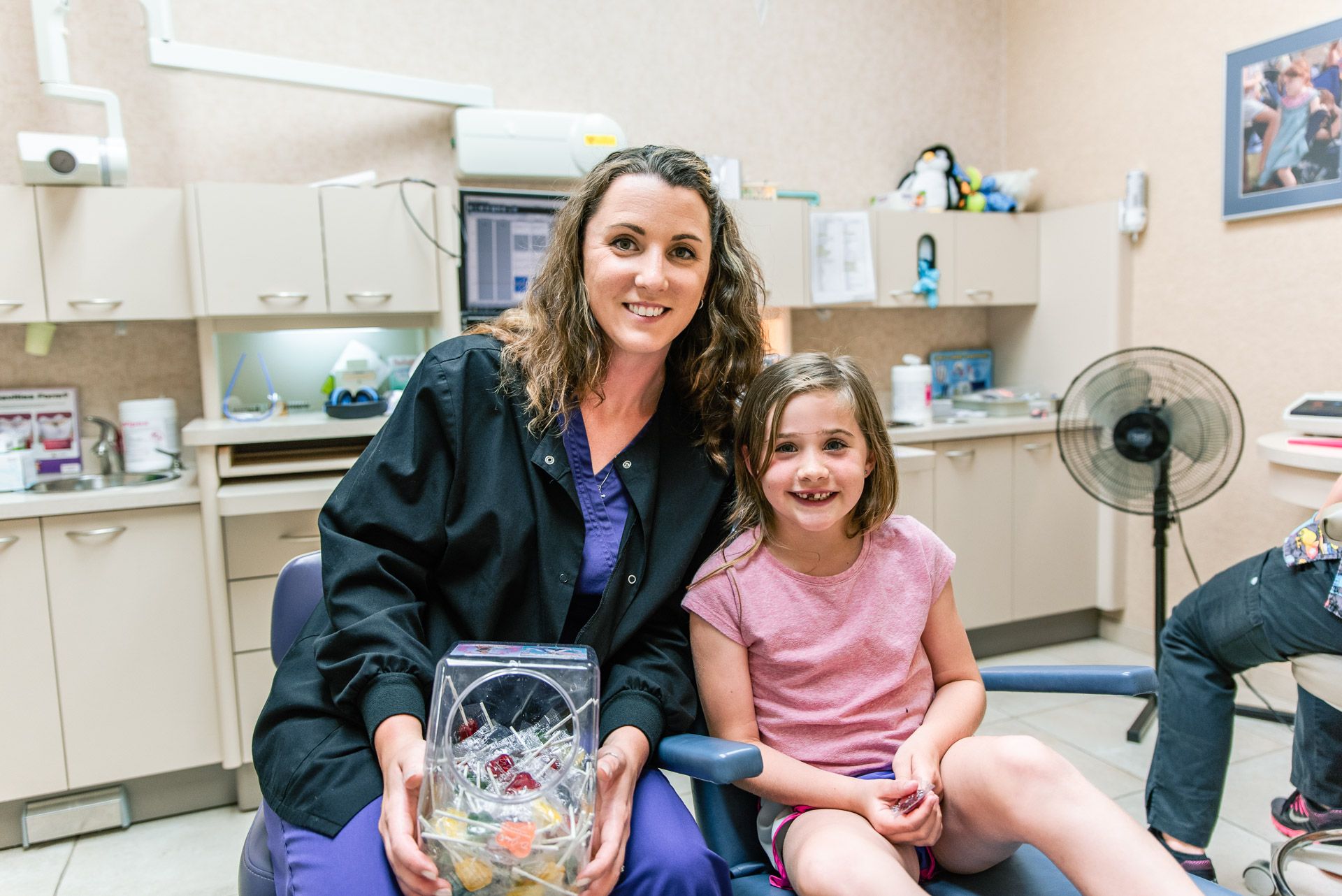 child in dentist chair with assistant