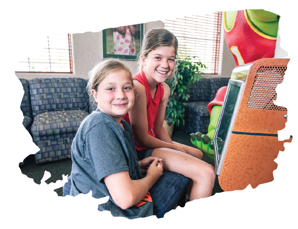 Two young patients are smiling while sitting in the waiting room